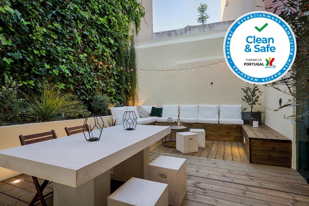 a patio with a table and chairs and a couch at Romantic Gem in Santos in Lisbon