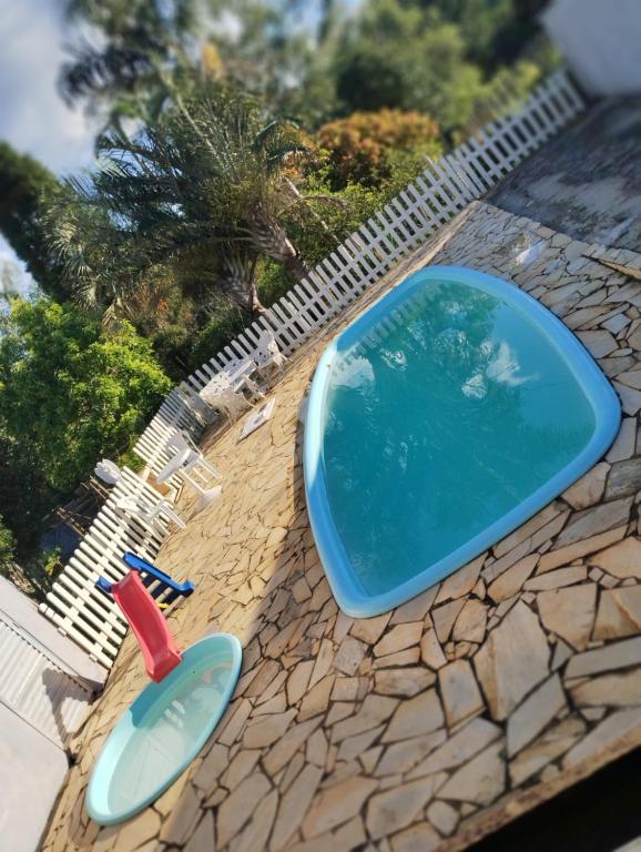 a swimming pool and a pair of slippers on a patio at Chácara lazer in Votorantim