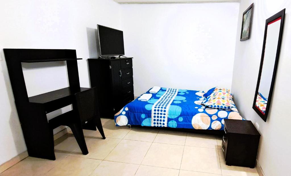 a bedroom with a bed and a television in it at Tu hogar lejos de casa. in Garzón
