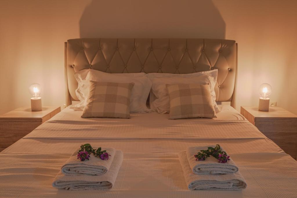 a bedroom with a bed with towels and two candles at Appartement pour deux personnes in Patitiri