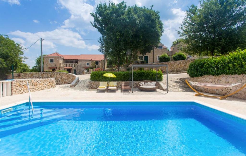 una piscina blu con patio e una casa di Villa Brkic with large private pool and playground a Brkići