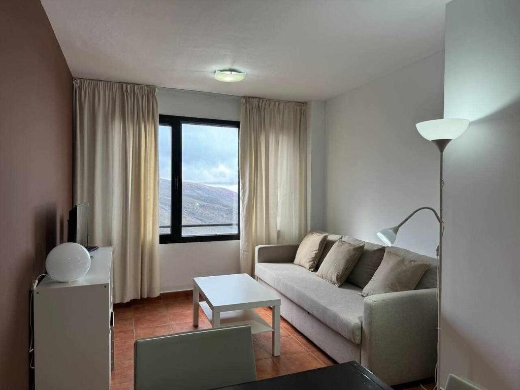 a living room with a couch and a large window at Apartamento Girasol in Sierra Nevada