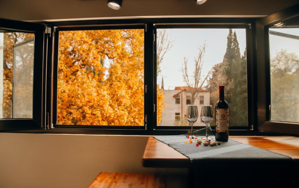 una mesa con dos copas de vino y una ventana en Mansarda House, en Tiflis