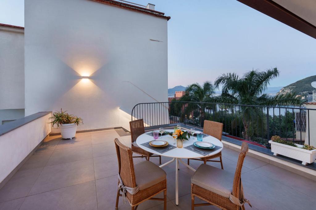 una mesa y sillas en un balcón con vistas en Enfasi Holiday Home en Vico Equense