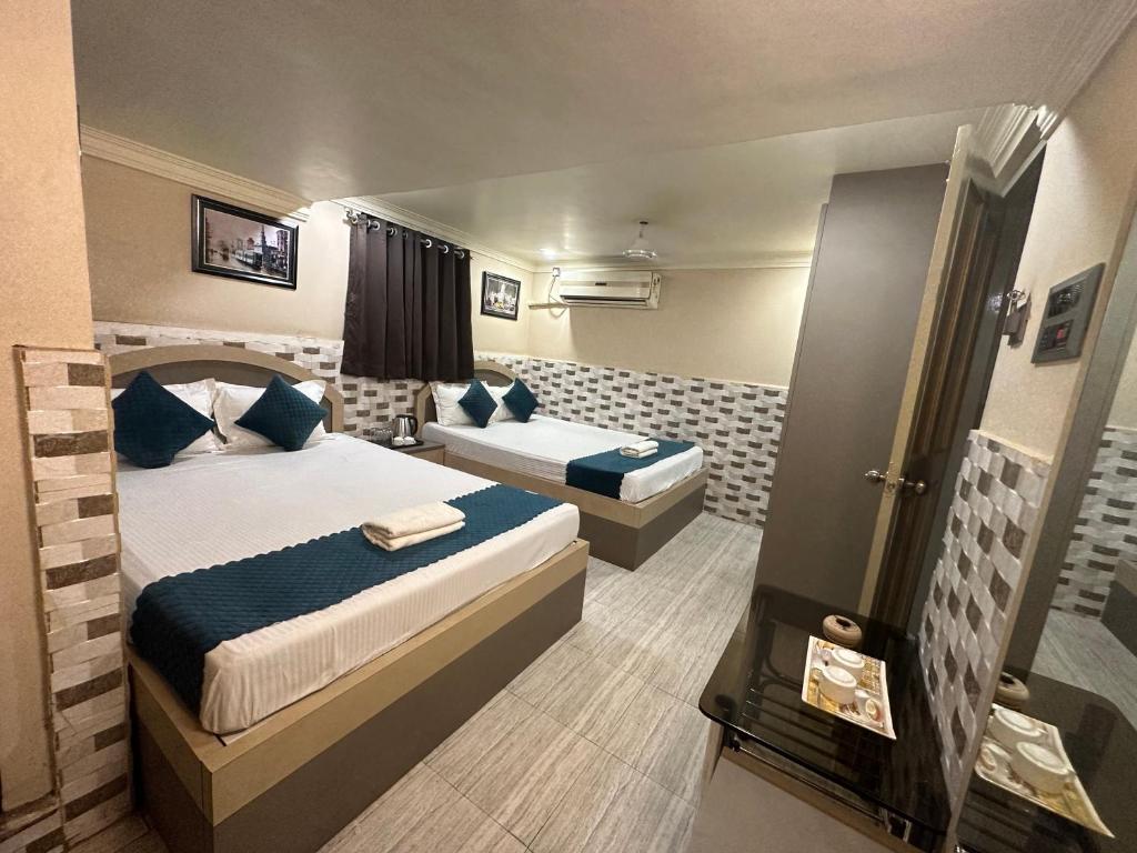 um quarto de hotel com uma cama e um sofá em Hotel Vinayak em Kharagpur