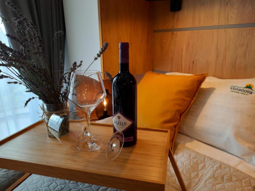 Una botella de vino y dos copas en una mesa en Vistanova Milmari S33, en Kopaonik
