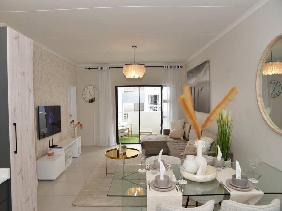 ein Wohnzimmer mit einem Sofa und einem Tisch in der Unterkunft Elcaro Luxury Villas-Urban Taupe in Midrand