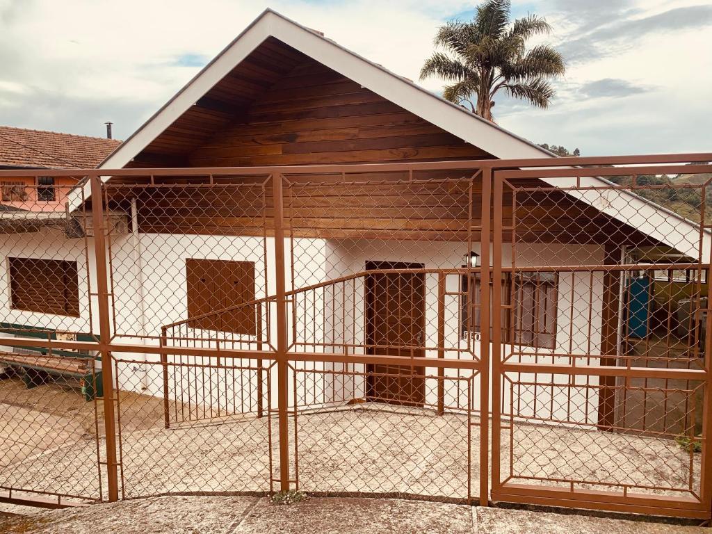 una casa de perros con una valla delante de ella en Cantinho do sossego en Campos do Jordão