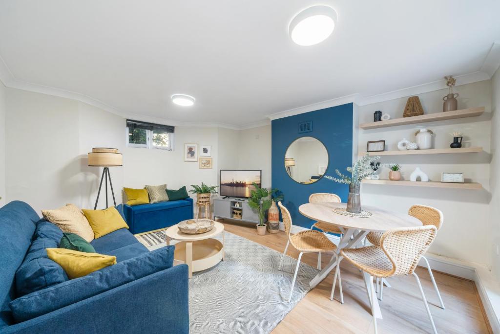 a living room with a blue couch and a table at Modern 2 BR near Arsenal Stadium in London