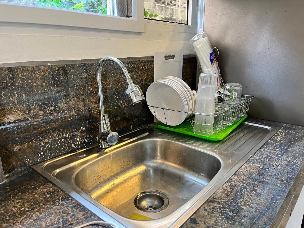 a kitchen sink with a faucet and a drying rack at Casa Tela in Tela