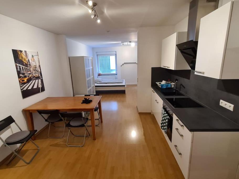 a kitchen with a wooden table and a dining room at City Central Apartment in Kaiserslautern
