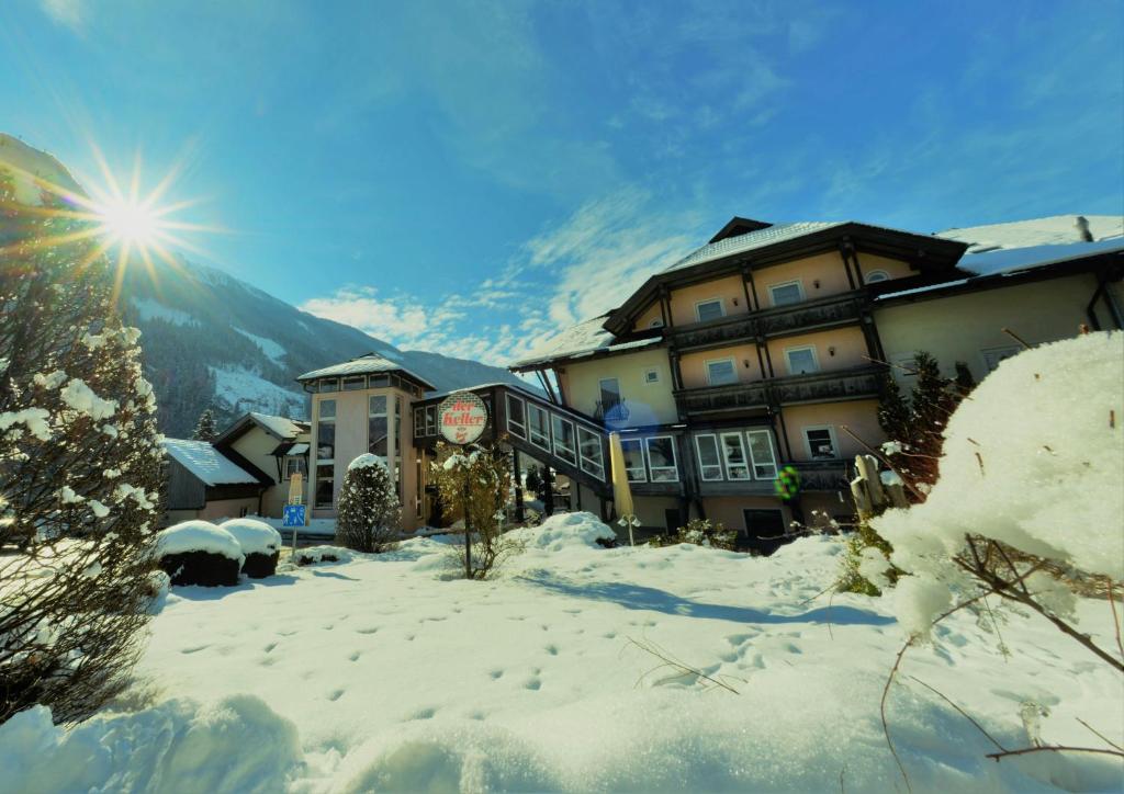 hotel w śniegu ze słońcem za nim w obiekcie Hotel Flattacher Hof w mieście Flattach