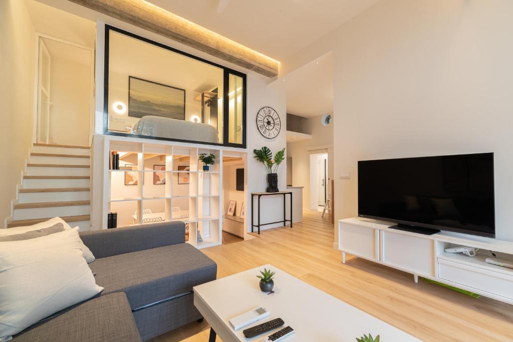 a living room with a couch and a television at Loft Playa Samil in Vigo