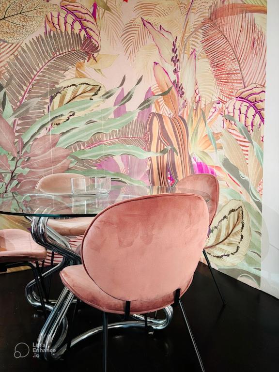 un tavolo con tre sedie rosa di fronte a un murale di Central Station Suite Bologna a Bologna