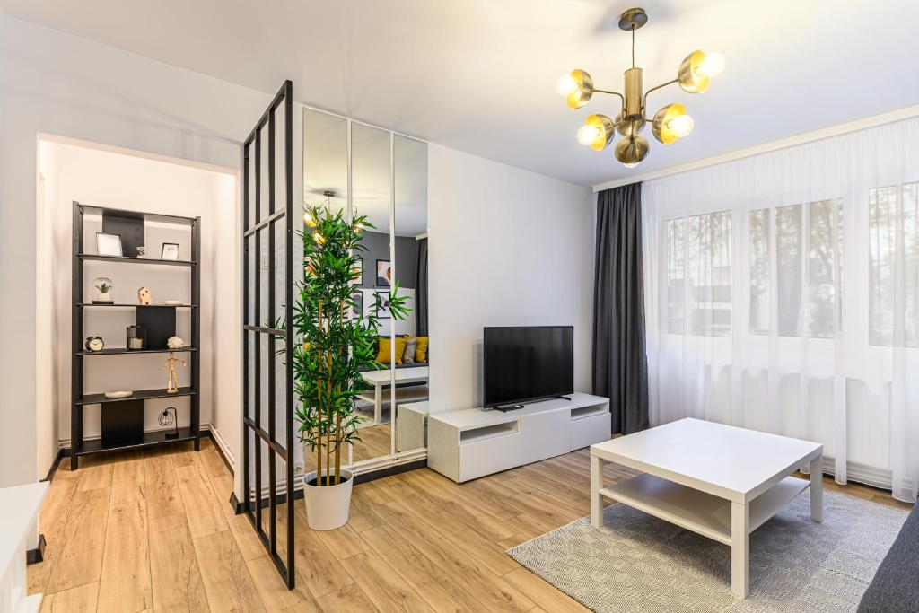 uma sala de estar com uma mesa e uma televisão em Travelers Hideout - Central Apartment em Brasov