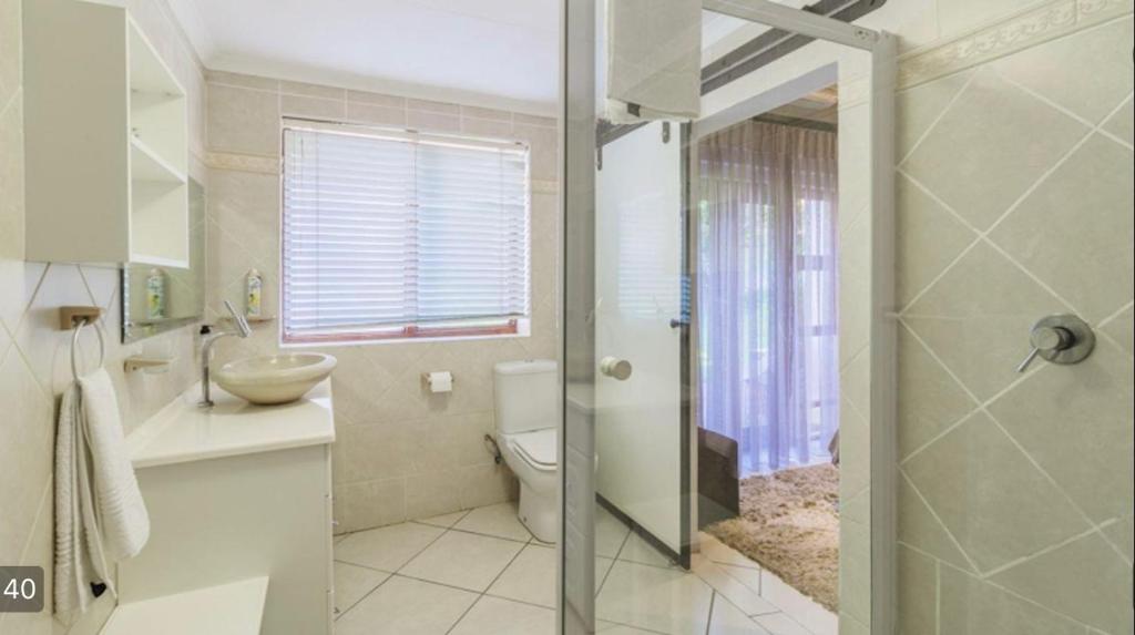 uma casa de banho com um WC, um lavatório e um chuveiro em Richtershuyz Luxury Accommodation em Pretoria