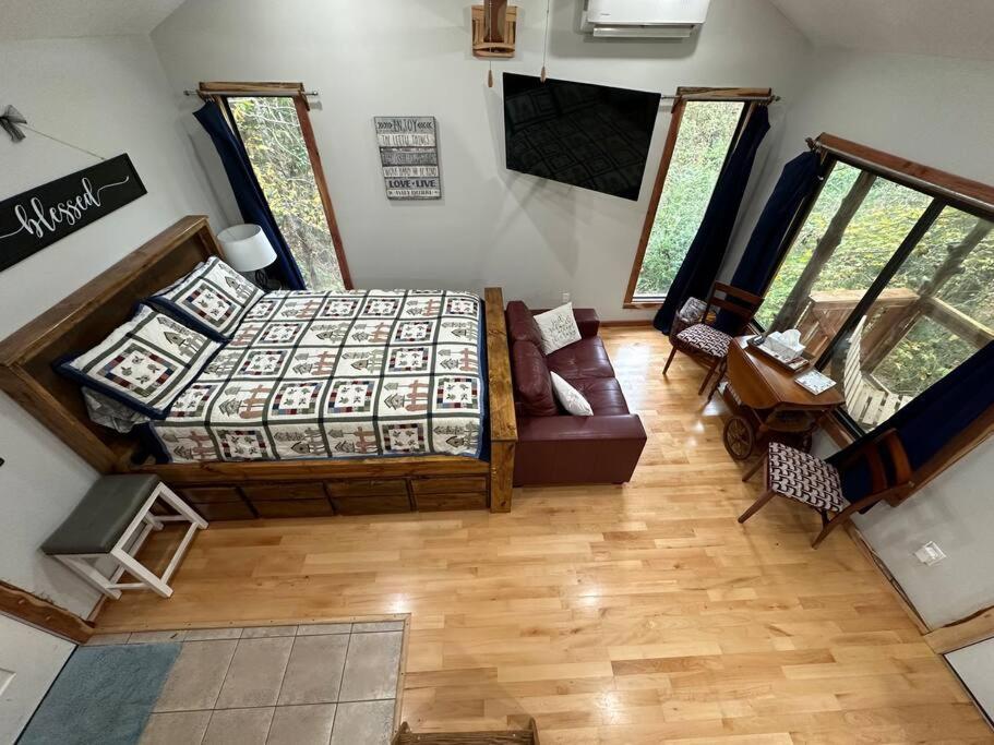 una vista sul soffitto di una camera da letto con un letto e un divano di Treehouse at Berry-patch a Longview