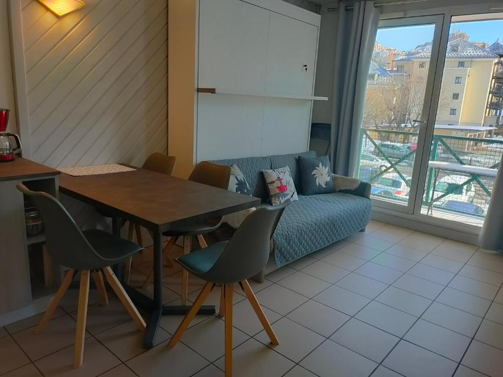 un soggiorno con tavolo, sedie e divano di Chez Maxime Pre du Moulin a Briançon