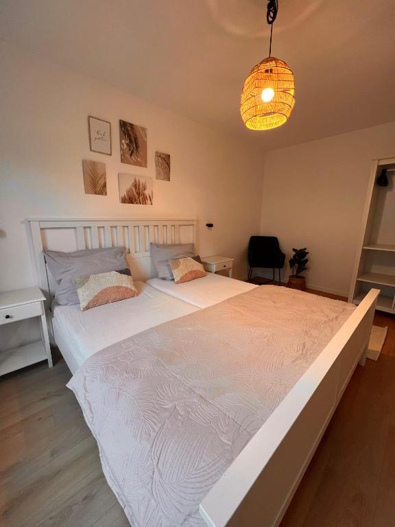 a large white bed in a bedroom with a lamp at Große Apartments für Monteure & Feriengäste in Dorsten
