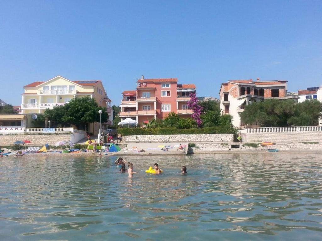a group of people in the water at a beach at Apartment Mare in Rab