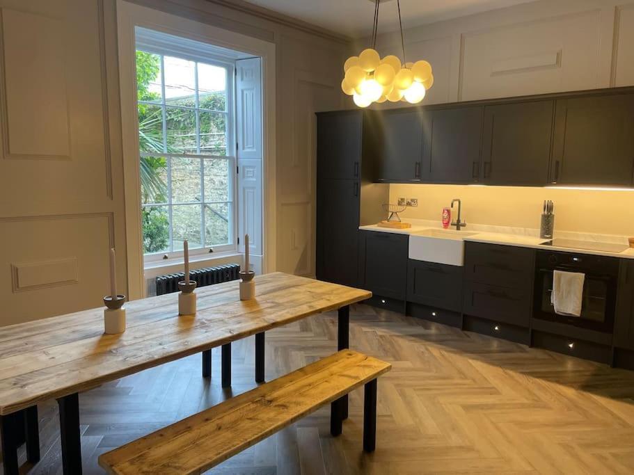 cocina grande con mesa de madera y ventana en No.8 Laura Place en Aberystwyth