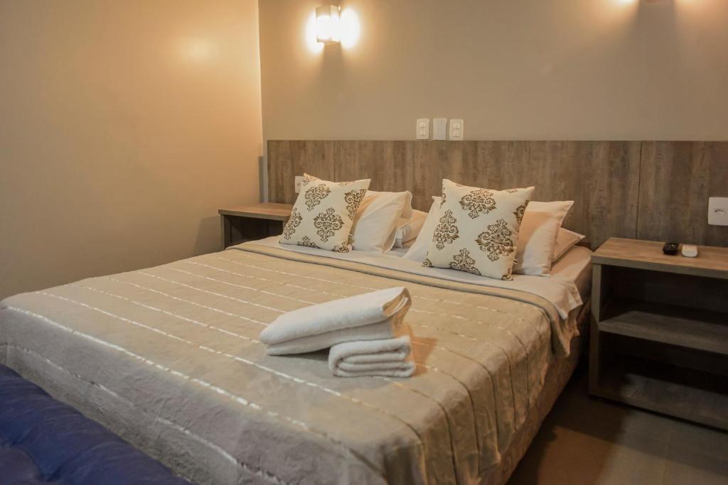 a bedroom with a bed with towels on it at Honorato Hotel by Easy Hotéis in Rio Verde