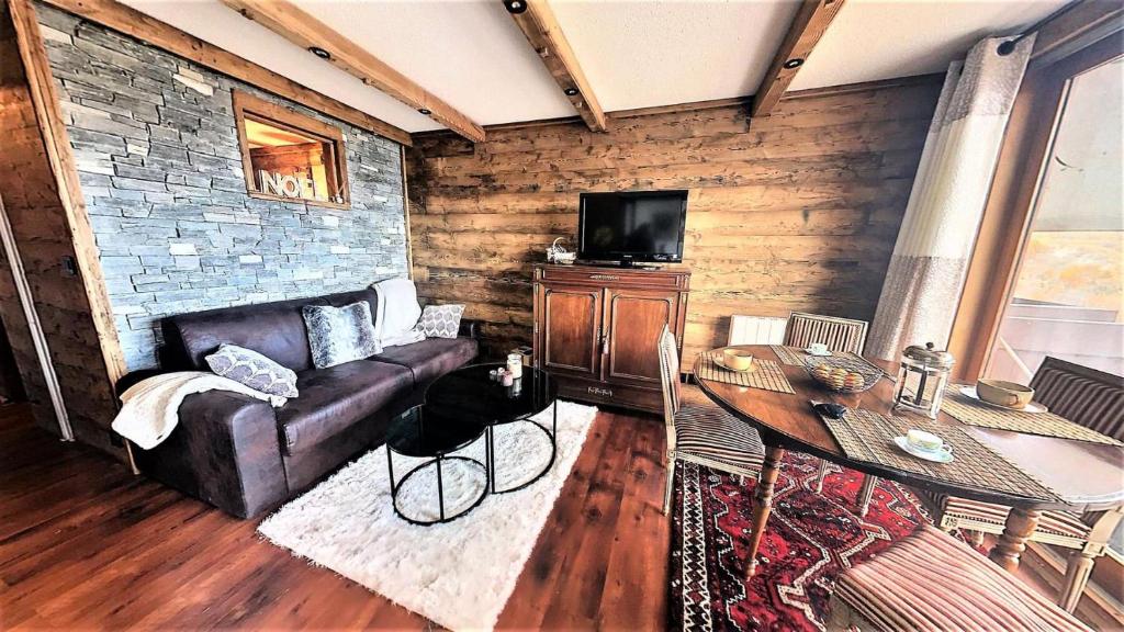 un salon avec un canapé en cuir et une télévision dans l'établissement Résidence Lunik - Appartement rénové · Pied des pistes · Balcon MAE-9381, à Villarembert