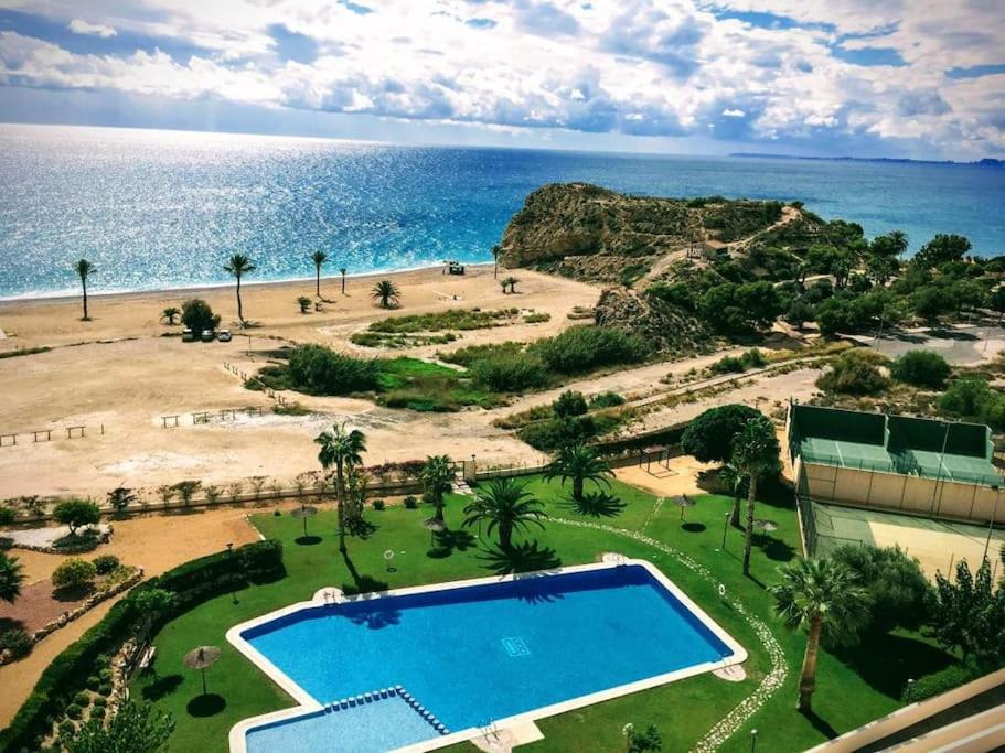 an aerial view of a resort with a swimming pool and the ocean at Top-Floor Beachfront Apartment with Parking, Pool, & Beautiful Sea-View Balcony in Villajoyosa