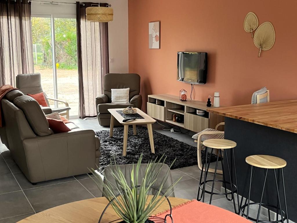 ein Wohnzimmer mit einem Sofa und einem TV in der Unterkunft LA VREMONTOISE in Mâcon
