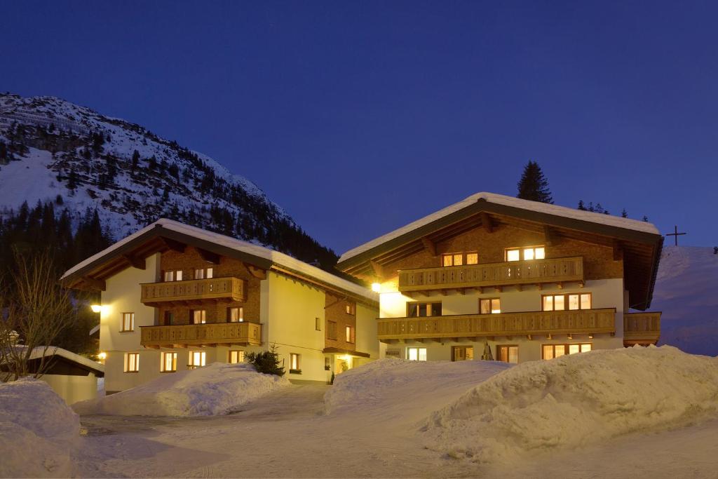 a building in the snow at night at Appartement Roggal in Lech am Arlberg