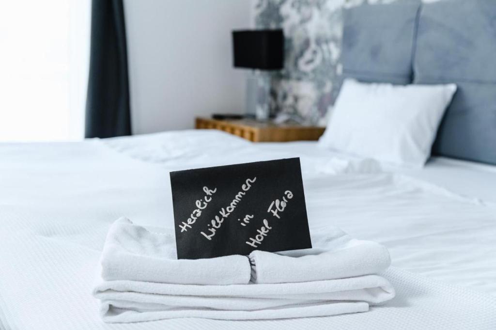 a book sitting on top of a bed with towels at Hotel Flora in Schwäbisch Gmünd