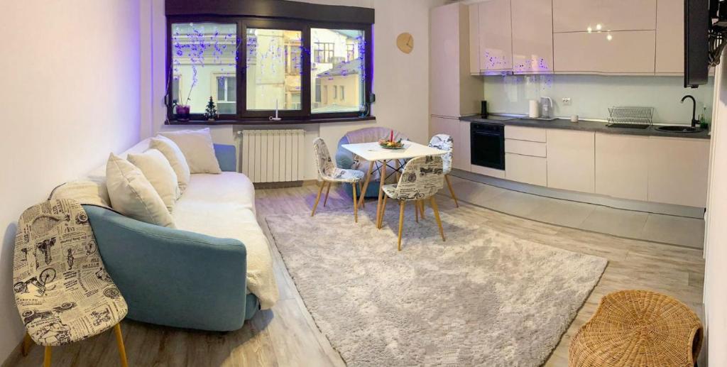 a living room with a couch and a table with chairs at Central apartment - Cismigiu & Izvor Park in Bucharest