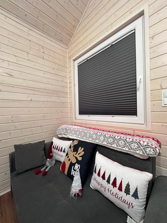 Cozy seating area with holiday pillows and wooden walls.