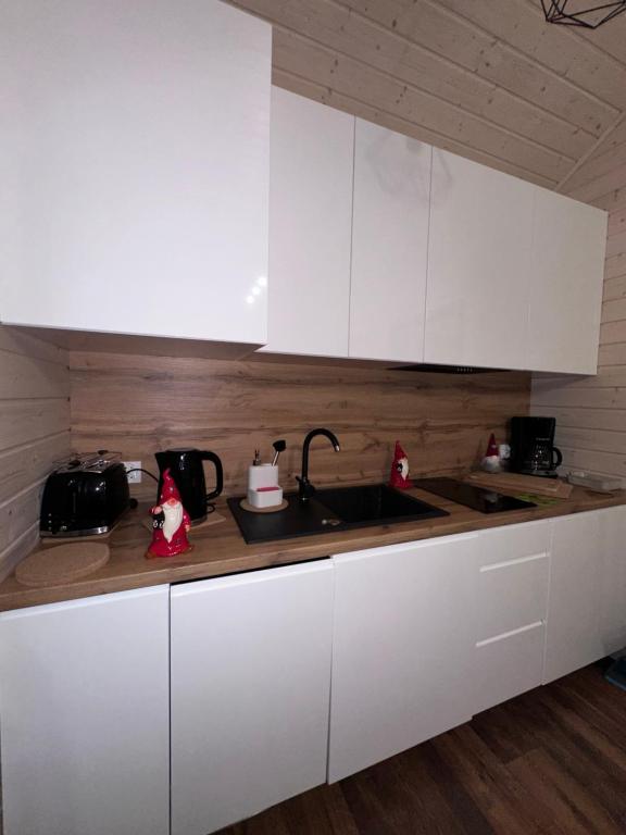 Compact kitchen with white cabinets and holiday-themed decor.
