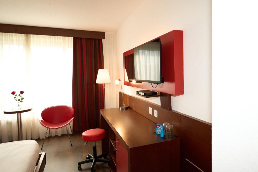 Televízia a/alebo spoločenská miestnosť v ubytovaní Hotel Conti Dietikon