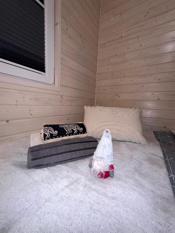 Bed with decorative towels and small gnome figurine.