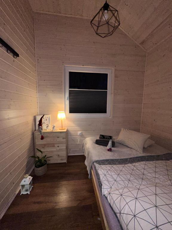 Bedroom with twin beds, nightstand, and warm lighting.