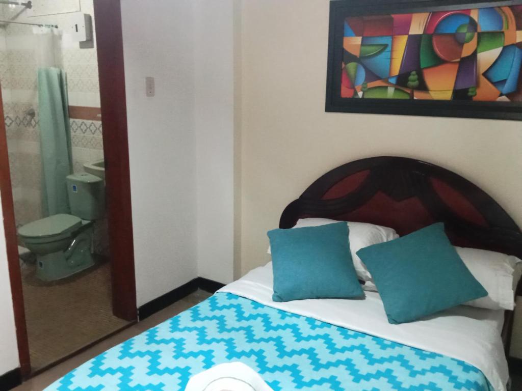 1 dormitorio con 1 cama con 2 almohadas azules en Casa Tundama, en Duitama