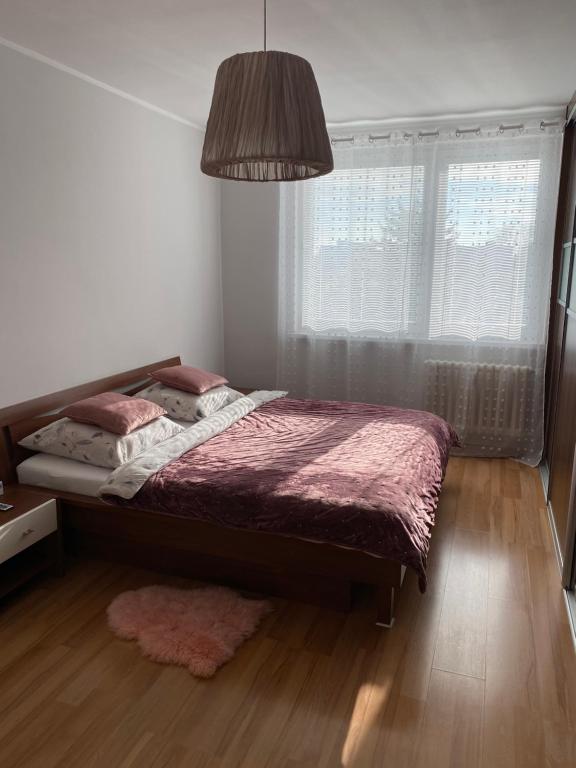a bedroom with a bed and a large window at City Apartment in Piešťany