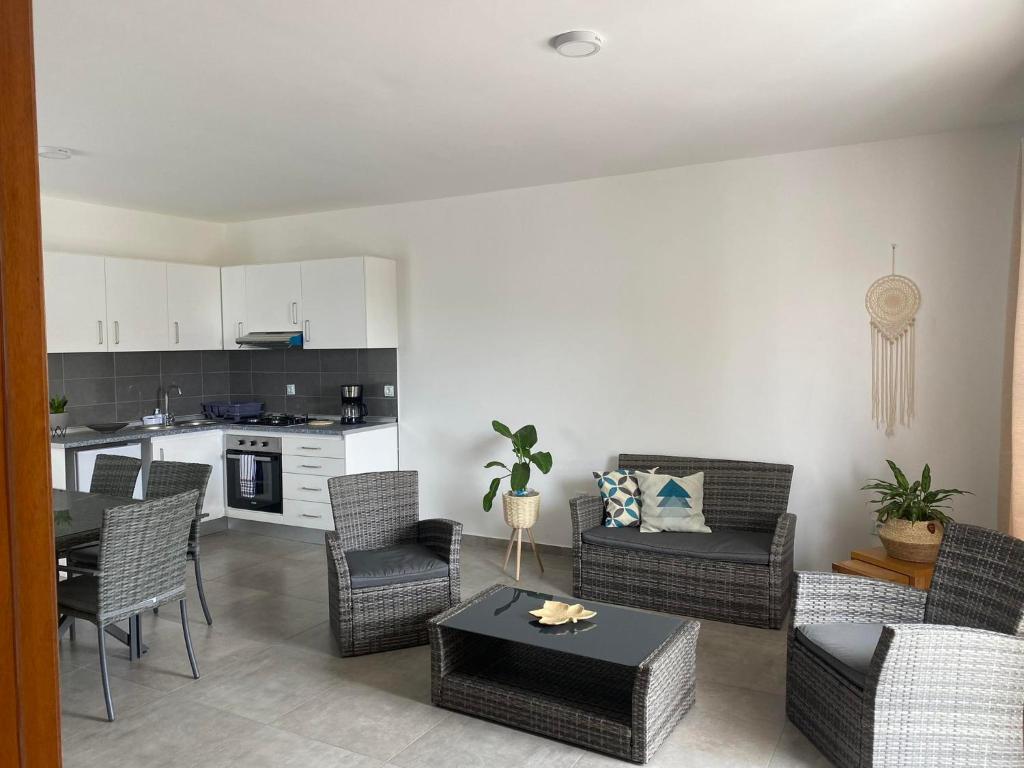 a living room with chairs and a table and a kitchen at Apartments A&A - Santa Maria in Santa Maria