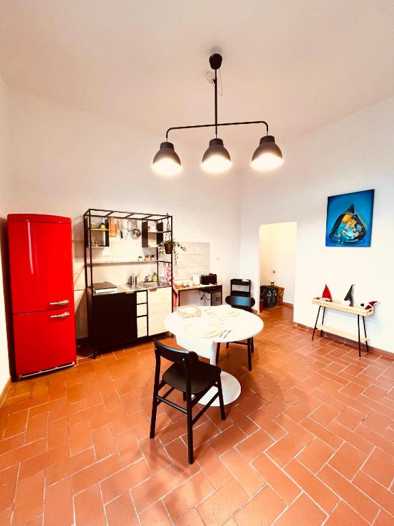 uma cozinha com uma mesa e um frigorífico vermelho em CasAmalia em Florença
