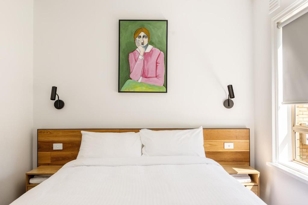 a bedroom with a bed and a painting on the wall at MAC South Yarra by Melbourne Apartment Collection in Melbourne