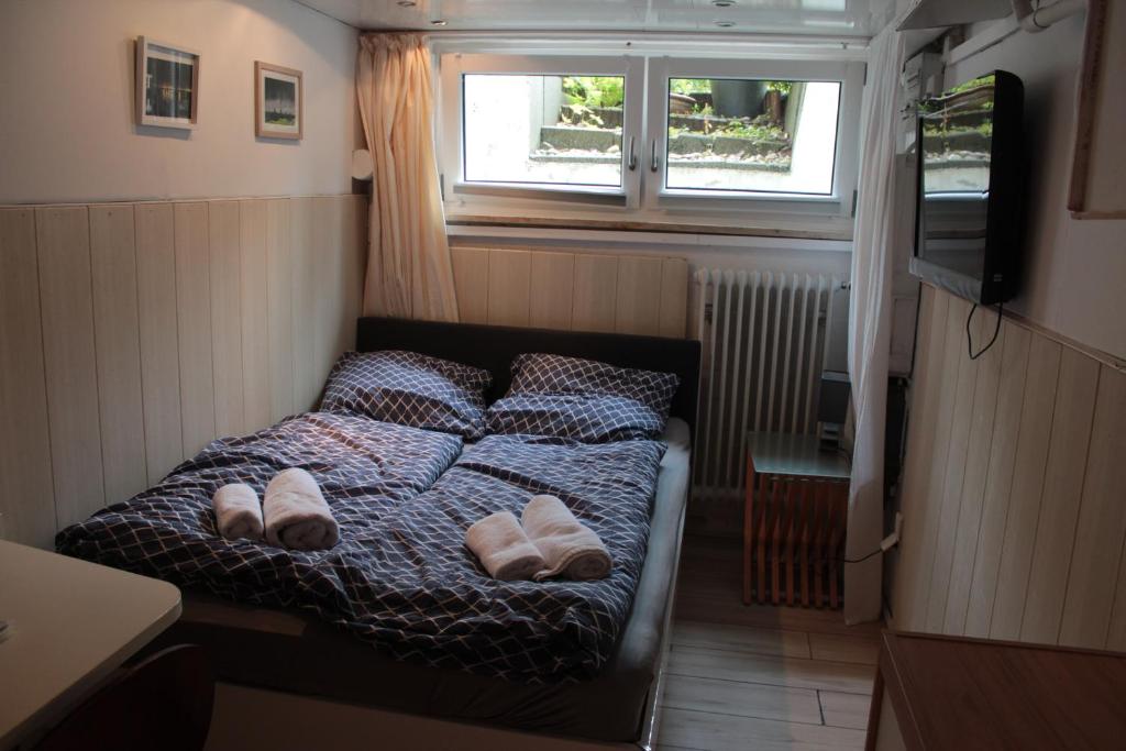 a small bedroom with a bed with slippers on it at Kleine Wohnung im Grünen in Hamburg