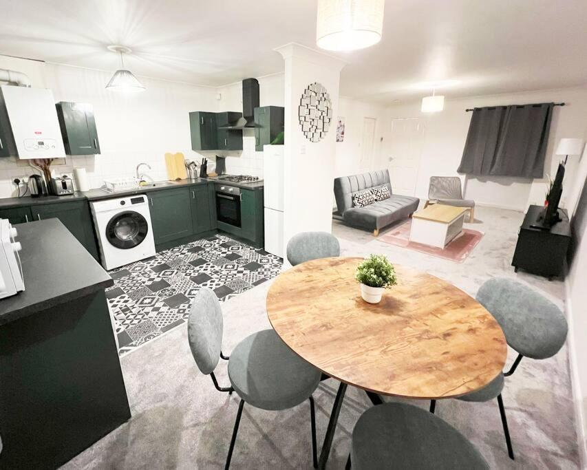 a kitchen and a living room with a table and chairs at Whitefield, Manchester in Manchester