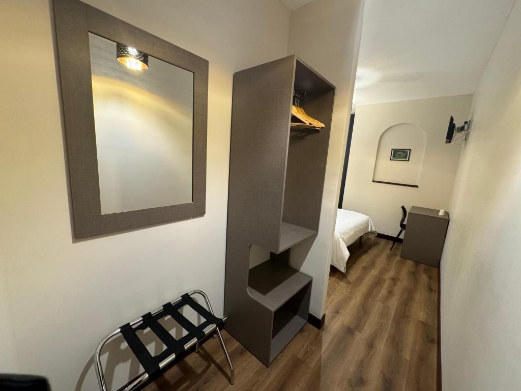 a room with a mirror and a bedroom with a bed at HÔTEL ROYAL MONTREUIL in Montreuil