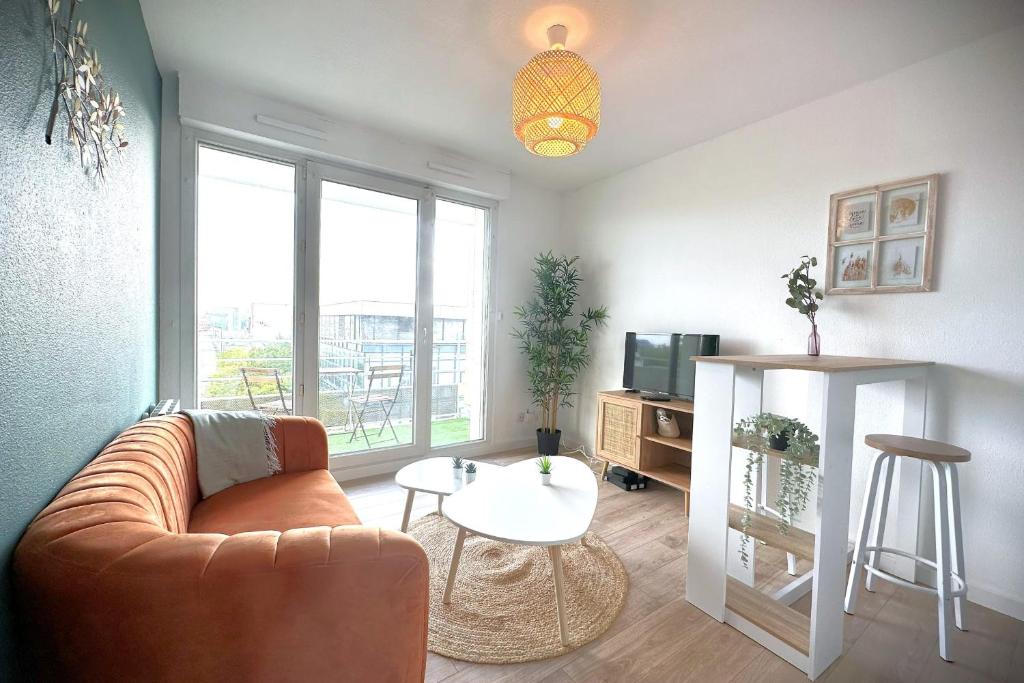un soggiorno con divano e tavolo di Le Sunset-Cosy appart avec parking et balcon a Le Havre