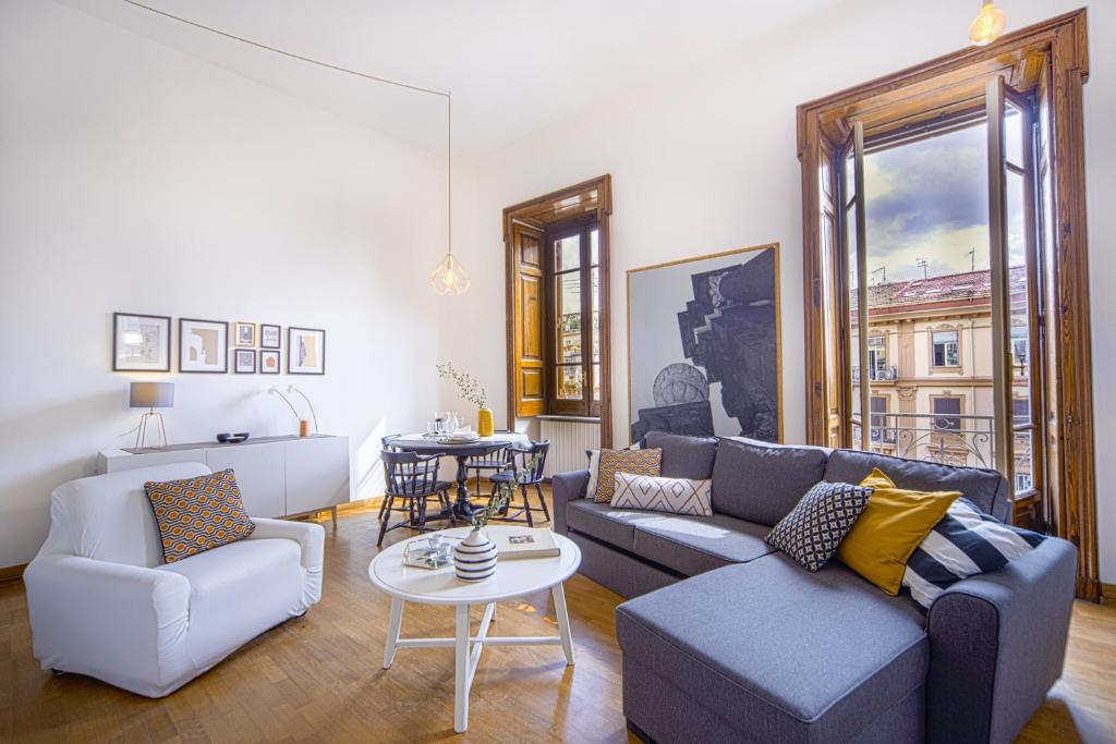 een woonkamer met een bank, stoelen en een tafel bij Casa Frangiò Modern Apartment Historical Centre in Napels