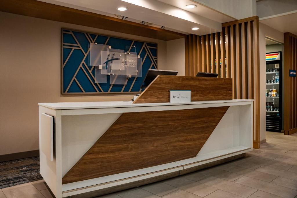 a reception desk in a lobby with wood at Holiday Inn Express Hotel & Suites West Chester, an IHG Hotel in West Chester