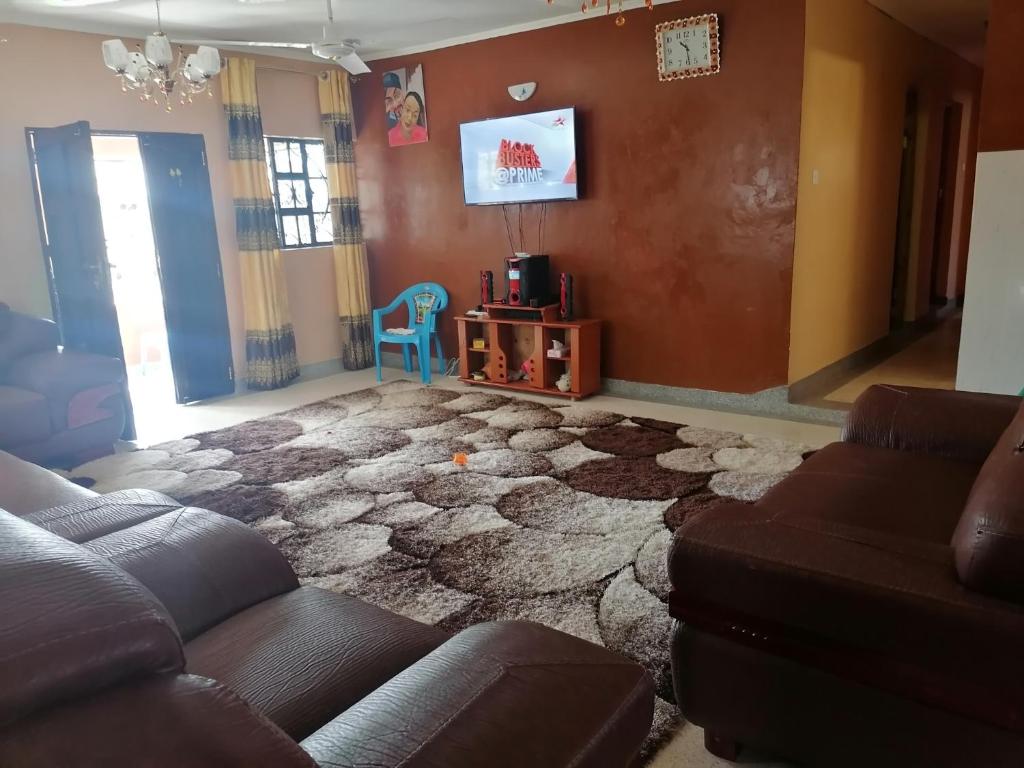 a living room with a couch and a tv at Rabai,Mazeras. Off Jumbo steel mills/kombeni girls before the coast line of Mombasa Kenya. in Kilifi