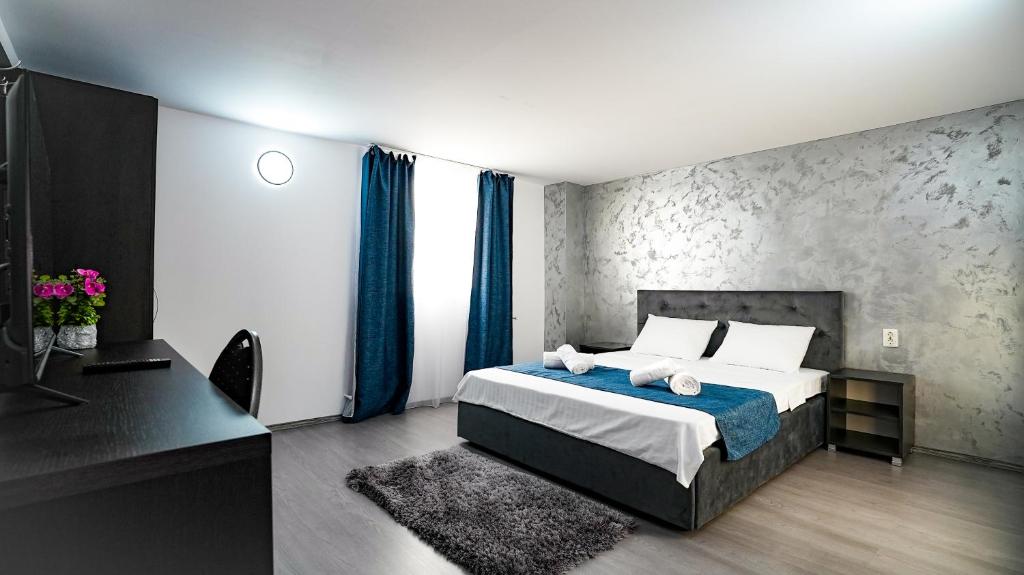 sypialnia z łóżkiem z niebieskimi zasłonami i biurkiem w obiekcie Casa de pe rau w mieście Telega